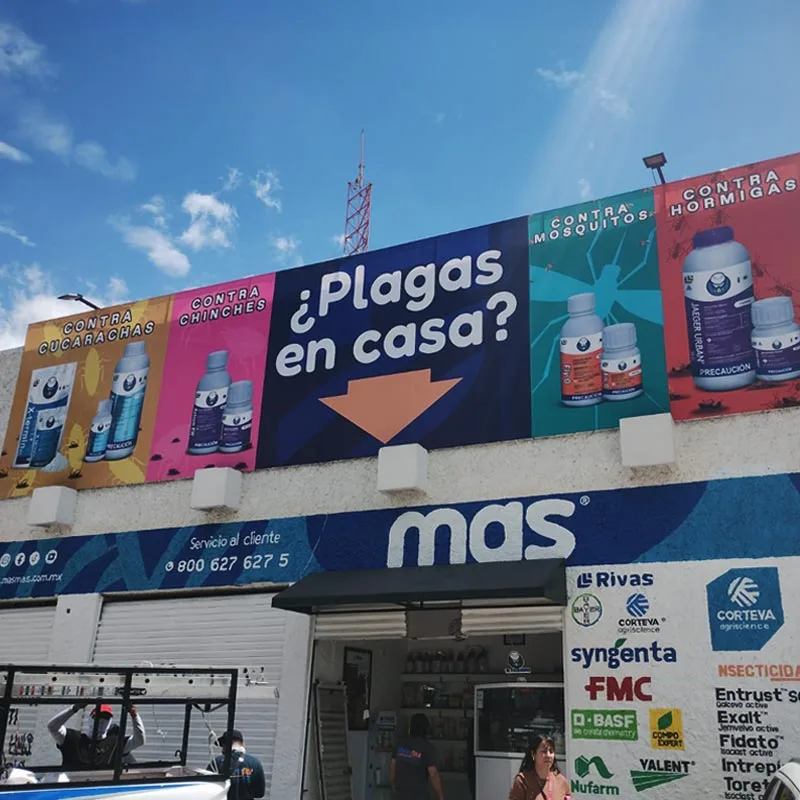 Fachada de tienda con anuncio publicitario grande en la parte superior, ejemplo de lona impresión de vinil exterior.