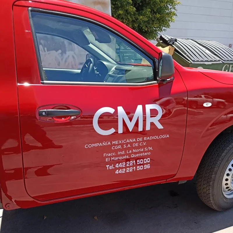 Impresión de lona y vinil Camioneta roja rotulada con logotipo “CMR” en puerta, ejemplo de rotulación vehicular.
